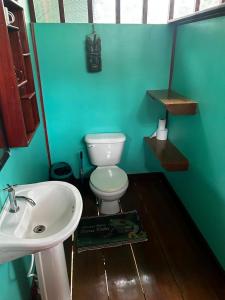 a bathroom with a white sink and a toilet at Nativos Corcovado cabins in Drake