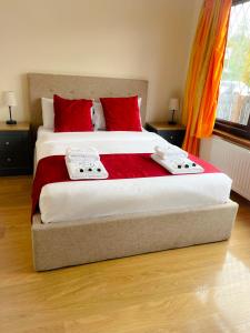 una camera da letto con un grande letto con cuscini rossi di Duddingston Guest House a Edimburgo