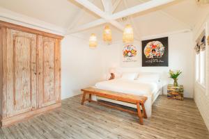a bedroom with a white bed and a wooden bench at Seminyak Villa Kubuku in Seminyak +42 photos