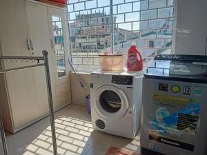 a washing machine in a kitchen with a window at Rose's House Hue in Hue