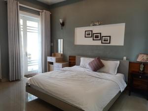 1 dormitorio con 1 cama con sábanas blancas y ventana en Rose's House Hue en Hue
