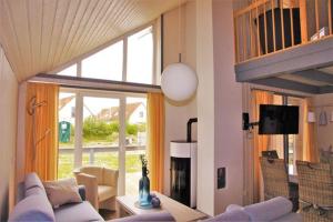 a living room with a couch and a tv at Seeschwalbe Classic 77 in Rechlin