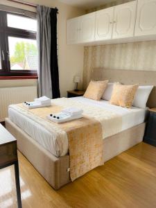 a bedroom with a large bed with two towels on it at Duddingston Guest House in Edinburgh