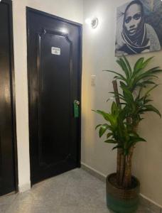 a black door in a hallway with a plant at Hotel boutique San Pablo in Medellín