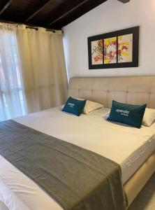 a bed with two blue pillows on top of it at Hotel boutique San Pablo in Medellín