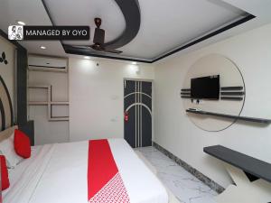 a bedroom with a bed and a tv on the wall at OYO Ruby Park Trivedi International Near Acropolis Mall in Kolkata