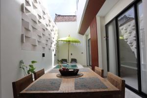 a dining room with a table and a yellow umbrella at Puspa Villa in Kerobokan