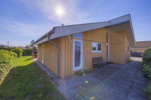 a small wooden house with a patio in a yard at Seeschwalbe 54 in Rechlin