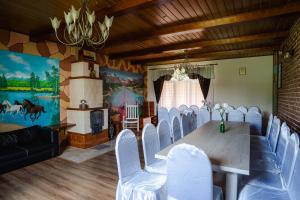 uma sala de jantar com uma mesa e cadeiras brancas em Gospodarstwo Agroturystyczne ZACISZE 