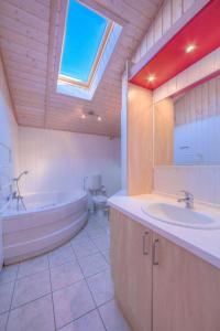 a bathroom with a tub and a sink and a toilet at Seeschwalbe 69A in Rechlin +7 photos