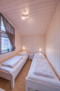 two twin beds in a room with a window at Seeschwalbe 74 in Rechlin