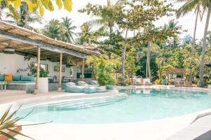 - une piscine dans un complexe avec des palmiers dans l'établissement Orion Healing Centre, à Srithanu