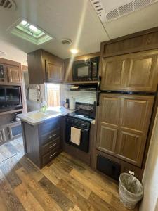 a kitchen with wooden cabinets and a stove top oven at Camper Rv1 with private entrance and free parking in Moreno Valley