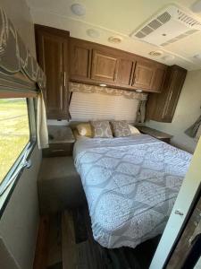una cama en la parte trasera de una caravana en Camper Rv1 with private entrance and free parking, en Moreno Valley