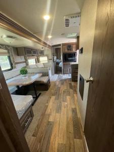 an rv living room with a table and a kitchen at Camper Rv1 with private entrance and free parking in Moreno Valley