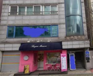 un edificio con una tienda rosa delante de él en JB Stay#Hongdae & Sinchon 10min#Double Room, en Seúl