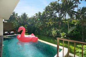 a pink rubber swan in a swimming pool at Dedary Resort Ubud by Ini Vie Hospitality in Ubud