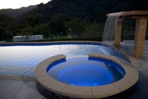 a large swimming pool with a large blue pond at Home with Infinity Pool and Mountain View in El Cajon