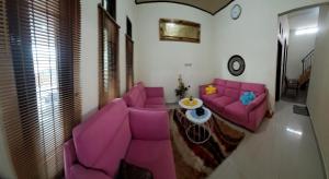 a living room with pink couches and a table at Vallery homestay in Geruntang