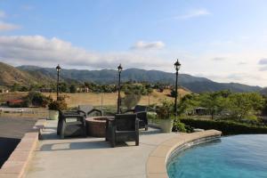 a patio with chairs next to a swimming pool at Home with Infinity Pool and Mountain View in El Cajon