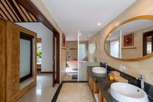 uma casa de banho com 2 lavatórios e um espelho grande em Dedary Resort Ubud by Ini Vie Hospitality em Ubud