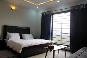 Un dormitorio con una cama grande y una ventana en AIRWAYS B&B Islamabad Free Airport Pick and Drop en Islamabad