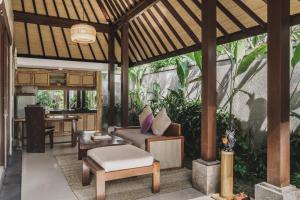 uma sala de estar exterior com uma pérgula de madeira em Dedary Resort Ubud by Ini Vie Hospitality em Ubud