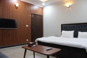 a hotel room with two beds and a coffee table at AIRWAYS B&B Islamabad Free Airport Pick and Drop in Islamabad