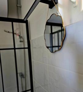 ein Spiegel hängt an einer Wand neben einer Dusche in der Unterkunft Lāsītes in Lielvārde