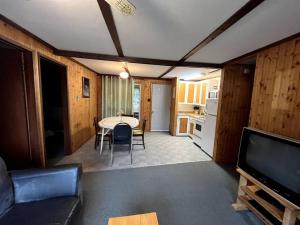 a living room with a table and a kitchen at Betula Lake Resort in Seven Sister Falls