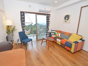 a living room with a couch and a chair at Churaumi Terrace in Motobu