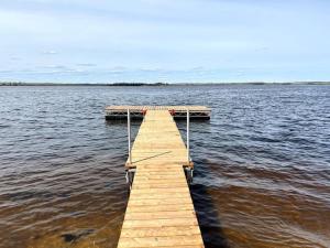 Betula Lake Resort في Seven Sister Falls: رصيف خشبي في وسط تجمع للمياه