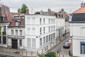 a row of white buildings on a city street at Le 84 Sainte-Cath' in Lille