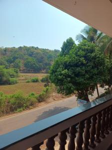 a balcony with a view of a road and a tree at Ashirwad Residency in Agonda