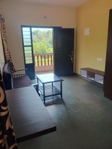 a living room with a table and a window at Ashirwad Residency in Agonda