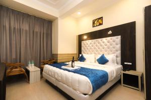 una camera da letto con un grande letto con una coperta blu di Hotel Grand Nest a Dharamshala