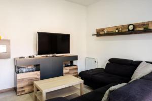 ein Wohnzimmer mit einem Sofa und einem Flachbild-TV in der Unterkunft Logement avec baignoire SPA Villa de luxe in Fonte Boa