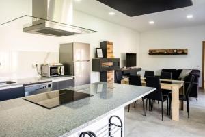 eine Küche mit einer Theke, einem Tisch und Stühlen in der Unterkunft Logement avec baignoire SPA Villa de luxe in Fonte Boa