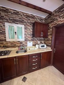 een keuken met een wastafel en een bakstenen muur bij Studio 2 in Sharm El Sheikh