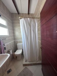 a bathroom with a toilet and a white shower curtain at Studio 2 in Sharm El Sheikh