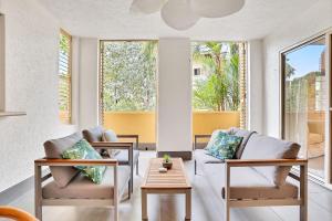 ein Wohnzimmer mit zwei Stühlen und einem Tisch in der Unterkunft Lotus Lakes - Resort Style Living in Cairns North