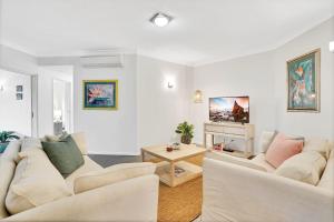 ein Wohnzimmer mit weißen Möbeln und einem Kamin in der Unterkunft Lotus Lakes - Resort Style Living in Cairns North