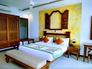 a bedroom with a large bed and a mirror at Randholee Resort & Spa in Kandy