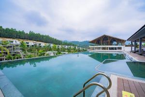 - une piscine d'eau bleue dans un complexe dans l'établissement Ivory Villa & Resort, à Hòa Bình
