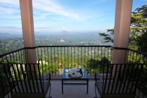 a table and chairs on a balcony with a view at Randholee Resort & Spa in Kandy