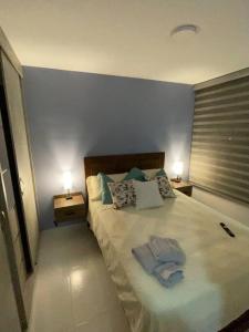 een slaapkamer met een groot bed met 2 nachtkastjes bij Tu casa en Cali. in Cali