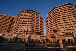 dois edifícios altos com palmeiras à frente deles em Rosarito Ocean View Paradise 12th Floor em Popotla