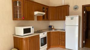 eine Küche mit einer weißen Mikrowelle und einem Kühlschrank in der Unterkunft Comfortable apartment on the Obolon in Kiew