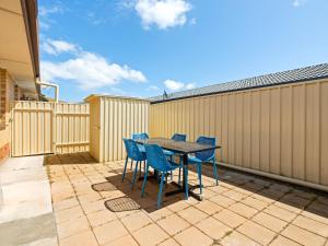 einen Tisch und Stühle auf einer Terrasse mit einem Zaun in der Unterkunft Hectorville Luxe Haven Suite in Campbelltown