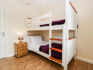 een slaapkamer met 2 stapelbedden en een nachtkastje bij Sherpa in Romsey